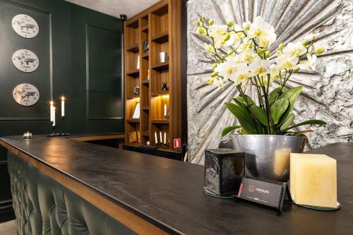 a bar with a vase of flowers on a counter at Abrazo Sofia Hotel by HMG in Sofia