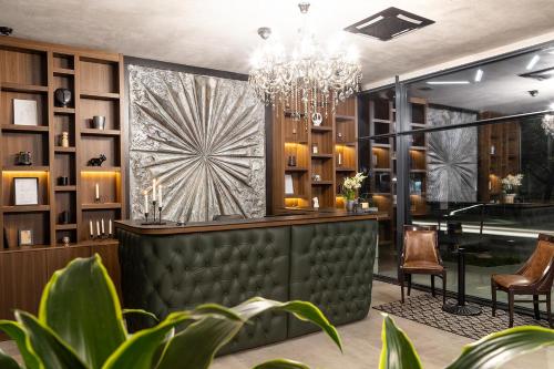 a bar with a chandelier in a restaurant at Abrazo Sofia Hotel by HMG in Sofia