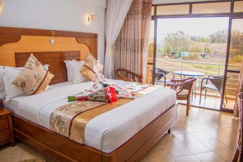 a bedroom with a bed and a balcony with a table at Grand Winston Hotel in Nakuru