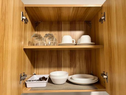 d'une armoire en bois avec des assiettes et de la vaisselle. dans l'établissement 7F Majorca, Camella Manors Bacolod Condo, à Bacolod