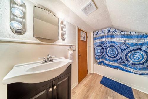 ein Bad mit einem Waschbecken und einem Duschvorhang in der Unterkunft Cottage in the Falls, 2 b, 2 bath, fireplace in Cuyahoga Falls