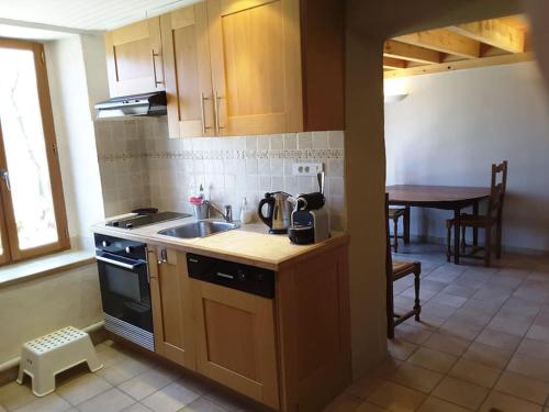 une cuisine avec un évier et une cuisinière dans l'établissement Grange en pierres. Grand jardin et belle vue, à Saurat