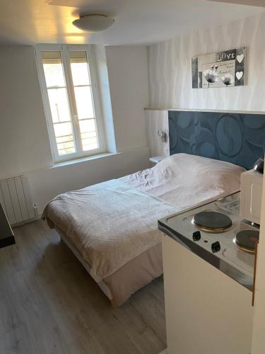 La Dilichambre في Carcagny: غرفة نوم صغيرة بها سرير وموقد