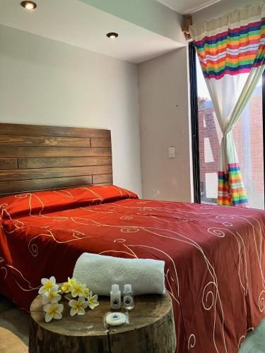 a bedroom with a bed and a table with flowers on it at Casa Biznaga in Oaxaca City