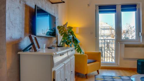 um quarto com uma secretária, uma cadeira e janelas em SPA apartment YANG - hot tub, sauna, spa em Novi Sad
