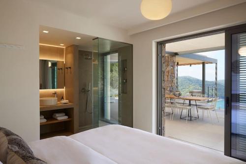 a bedroom with a bed and a view of a bathroom at Ohlive II sea view Kechria in Skiathos Town