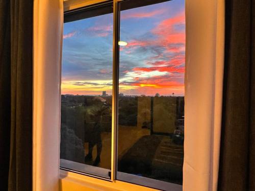 a window with a view of a sunset at 7F Majorca, Camella Manors Bacolod Condo in Bacolod