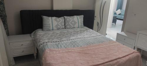 - une chambre avec un lit doté d'une couverture et d'oreillers roses dans l'établissement Ataş, à Arnavutköy