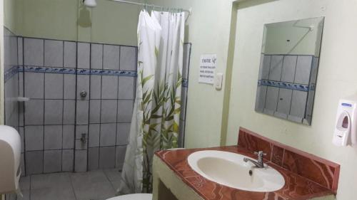 a bathroom with a sink and a shower and a toilet at Cabinas Bahía Uvita - Marino Ballena National Park Lodge in Uvita