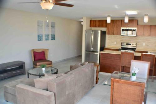 a living room with a couch and a kitchen at Blue Sky 1 bedroom apartment in Simpson Bay in Koolbaai