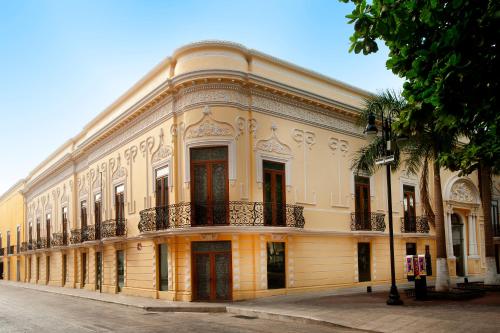 a large yellow building with balconies on a street at Mansi&oacute;n M&eacute;rida Boutique Hotel - Restaurant in M&eacute;rida