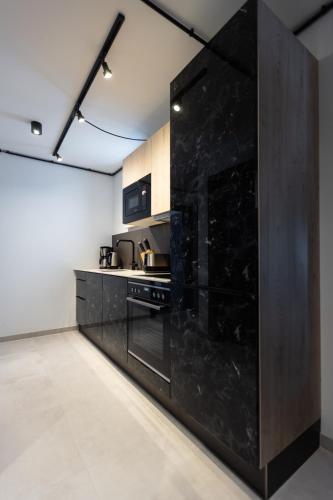 a kitchen with a large black wall at CARPE SOLEM Jules in Obertauern