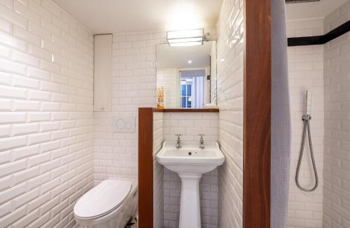 a white bathroom with a sink and a toilet at Élégant studio avec mezzanine porte des Ternes in Paris