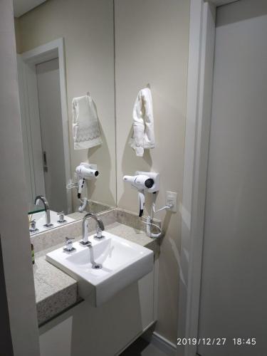 a bathroom with a sink and a mirror at Unique (Ex-Estanconfor) Ar Cond, e sacada fechada Apto 1210 in Santos