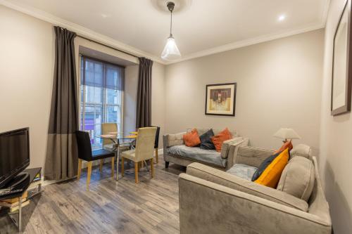 a living room with two couches and a dining room at Two Bedroom Apartment Within Walking Distance to City Centre in Edinburgh