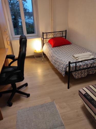 um quarto com uma cama, uma cadeira e uma secretária em Appartement calme dans quartier résidentiel. em Nancy