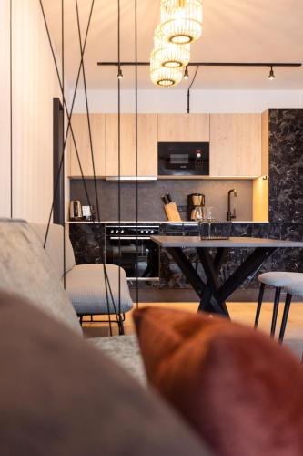 a living room with a table and a kitchen at CARPE SOLEM Jules in Obertauern