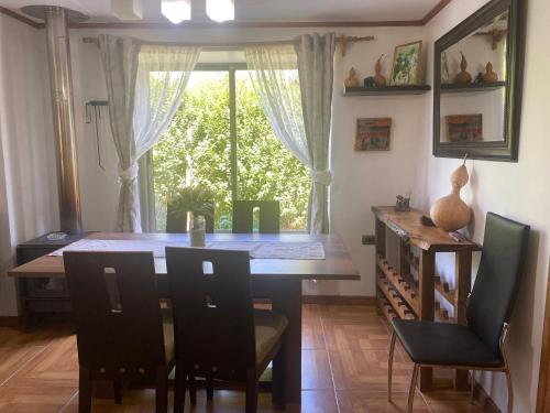 ein Esszimmer mit einem Tisch, Stühlen und einem Fenster in der Unterkunft Casa de Campo Reina Margarita in Santa Cruz