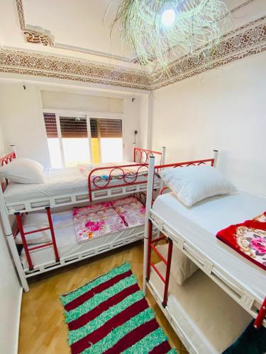 two bunk beds in a room with a ceiling at Azoul Surf Hostel Taghazout in Taghazout