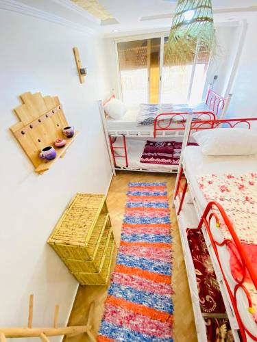 a room with two bunk beds and a rug at Azoul Surf Hostel Taghazout in Taghazout