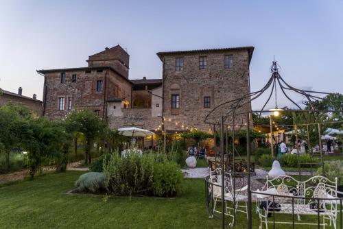 a garden with chairs and a building in the background at Abbazia Sette Frati Agriturismo Fratres in Pietrafitta