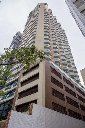 a tall building with a tree in front of it at Estanconfor Santos Vista Mar 4 AC Garagem sacada fechada in Santos