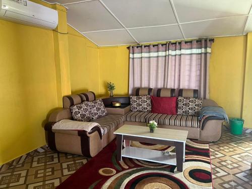 un soggiorno con divano e tavolo di Old House Villa a Sauraha