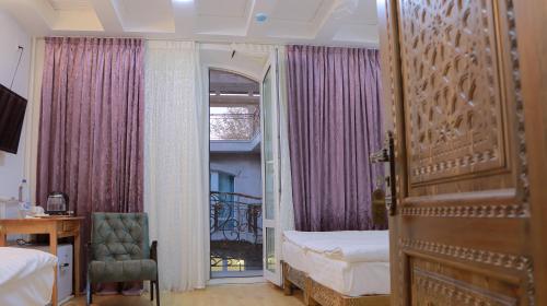 een slaapkamer met een bed en een raam met paarse gordijnen bij Prestige Terrace Hotel in Bukhara