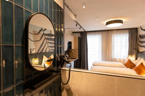 a hotel room with a mirror and a bed at CARPE SOLEM Jules in Obertauern