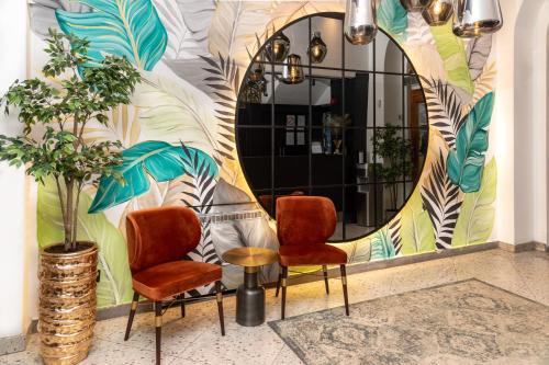 two chairs and a table in front of a mirror at Natali luxury suites- mini rooms in Belgrade