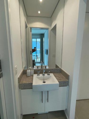 a bathroom with a sink and a large mirror at Unique (Ex-Estanconfor) veja o mar do apto 1706 in Santos