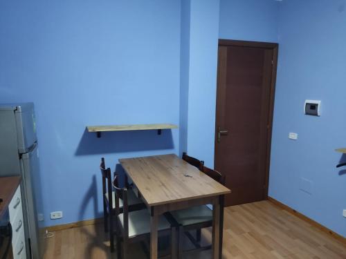 une table et des chaises dans une pièce dotée d'un mur bleu dans l'établissement Affittacamera Mauro vasto, à Vasto