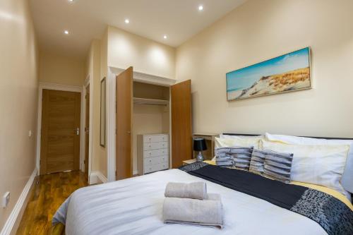una camera da letto con un grande letto bianco e una sedia di New 3-Bedroom Apartment Close to City Centre a Edimburgo