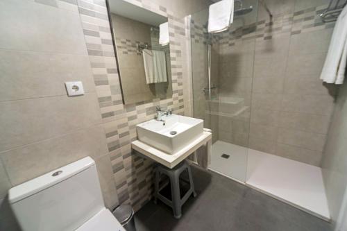 a bathroom with a sink and a shower and a toilet at Hostal Anna Benidorm in Benidorm