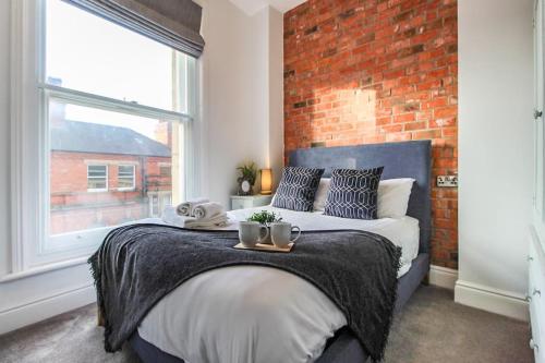 - une chambre avec un grand lit et un mur en briques dans l'établissement Luxurious City Centre Lace Market Apartment, à Nottingham