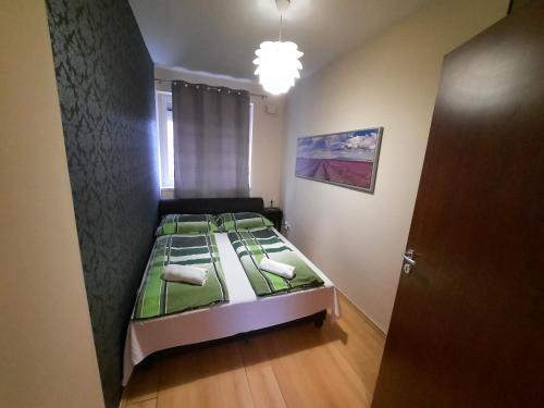 um quarto com uma cama com lençóis verdes em Boróka Apartman em Hajdúszoboszló