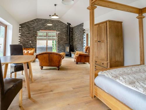 a bedroom with a bed and a table and chairs at Ty Afon Arch - Uk38515 in Garnant