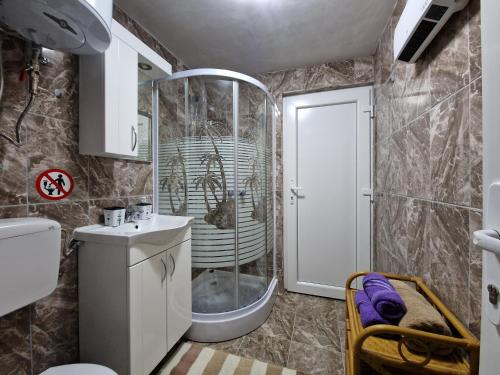 a bathroom with a shower and a sink and a toilet at Apartmani Kubo in Kakanj