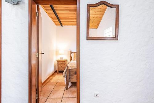 a door leading into a bedroom with a mirror at Ivy Cottage by Madeira Sun Travel in Faial