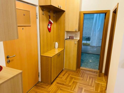 a room with a door and a kitchen with wooden floors at Jolly Apartment - Belgrade in Belgrade