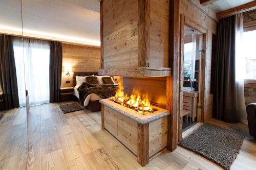 a living room with a fireplace and a bed at Sci Sport rooms & suites in Bormio