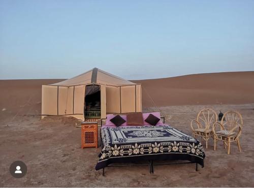 a bed in a tent in the desert at Peace of mind camp in Mhamid