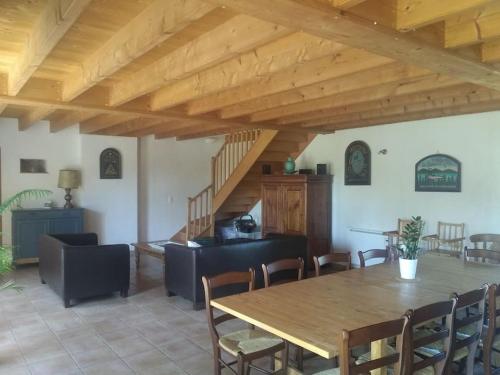 une salle à manger avec une table et des chaises en bois dans l'établissement La Faerie - A la campagne - Gite 18 personnes, à Grand-Landes