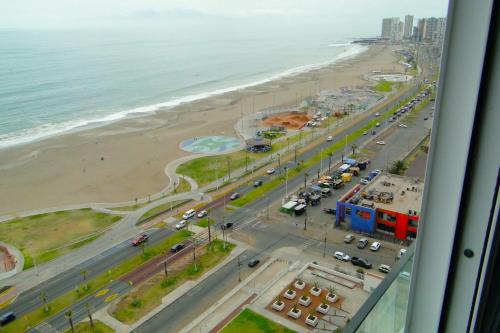 a view of a beach and the ocean from a window at La mejor vista de la playa en Iquique in Iquique
