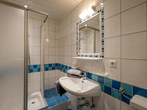 a bathroom with a sink and a shower and a mirror at Kröpflhof in Sankt Johann in Tirol