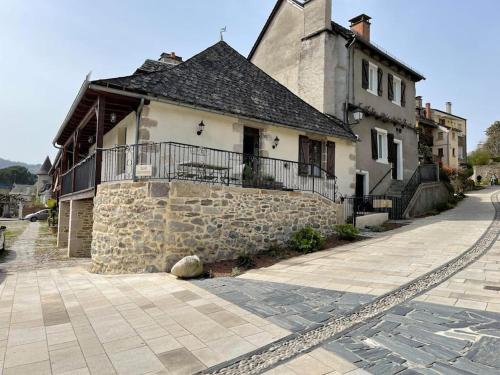 um edifício com uma parede de pedra ao lado de uma rua em Maison en pierre sur les Quais de la Dordogne em Argentat