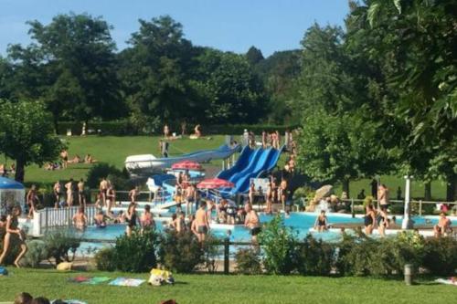 um grupo de pessoas em uma piscina em um parque em Maison en pierre sur les Quais de la Dordogne em Argentat