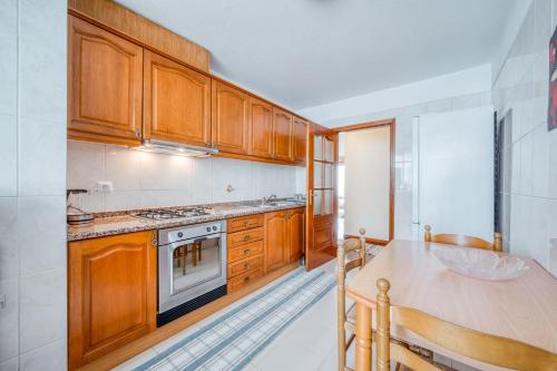 a kitchen with wooden cabinets and a table at Apartamento Vista Azul in Funchal