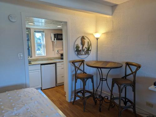 a small kitchen with a table and two bar stools at Waterway Condo at Wrightsville! in Wilmington