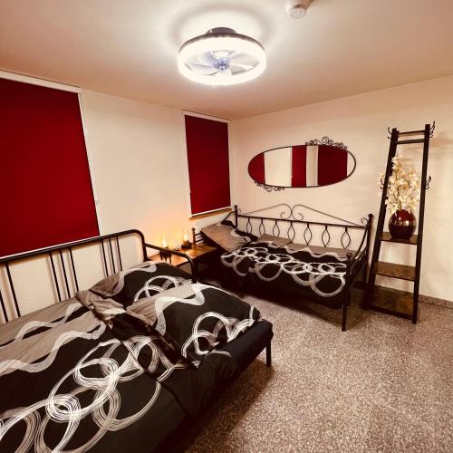 2 camas en una habitación con paredes rojas y blancas en Rose Boardinghouse, en Großbottwar